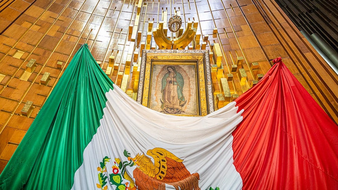 Our Lady of Guadalupe image inside Basilica of Guadalupe with Mexican flag.