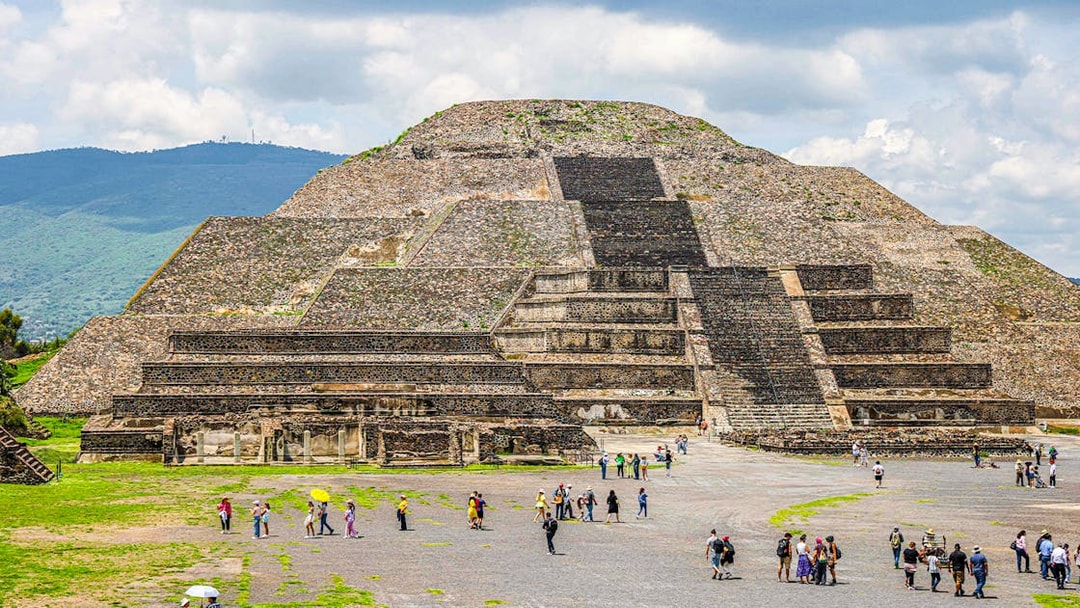 Pyramid of the Moon in Teotihuacan, Mexico, with visitors exploring the site.