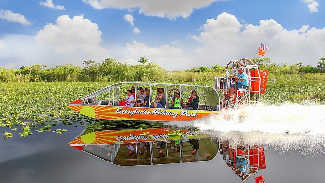 Airboat tour at Everglades Holiday Park with passengers enjoying the ride through wetlands.