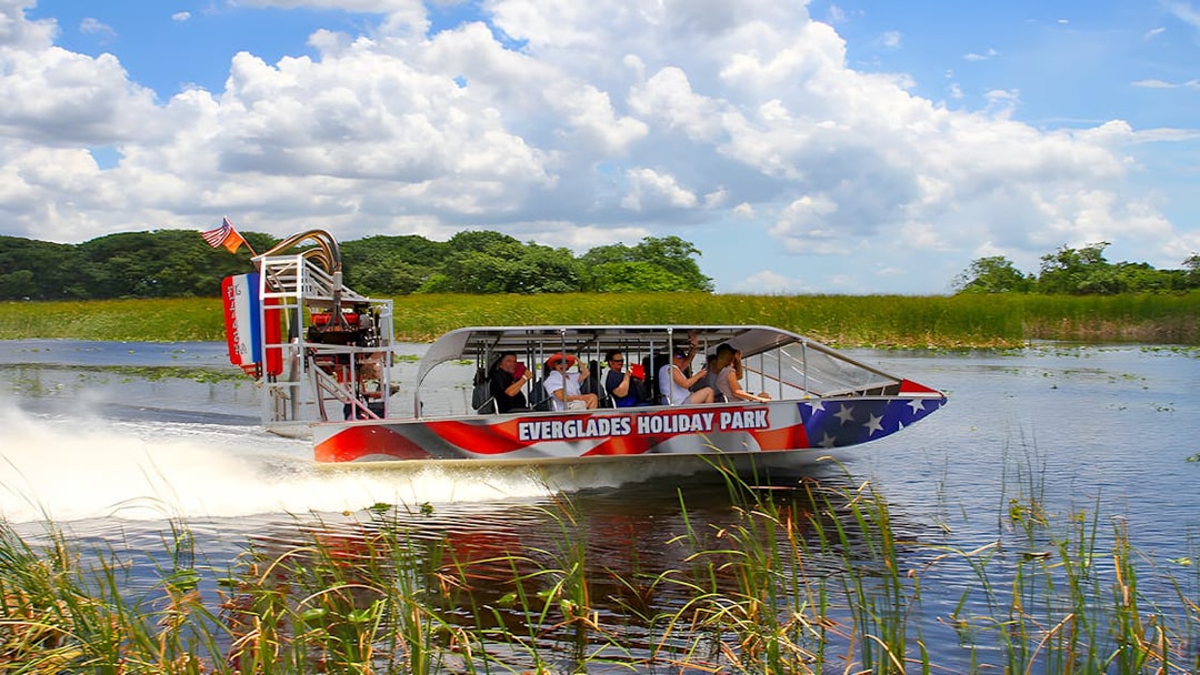 Airboat tour at Everglades Holiday Park with passengers exploring wetlands.