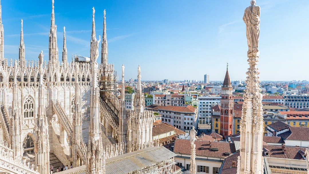 Milan Duomo rooftop view with cityscape in the background.