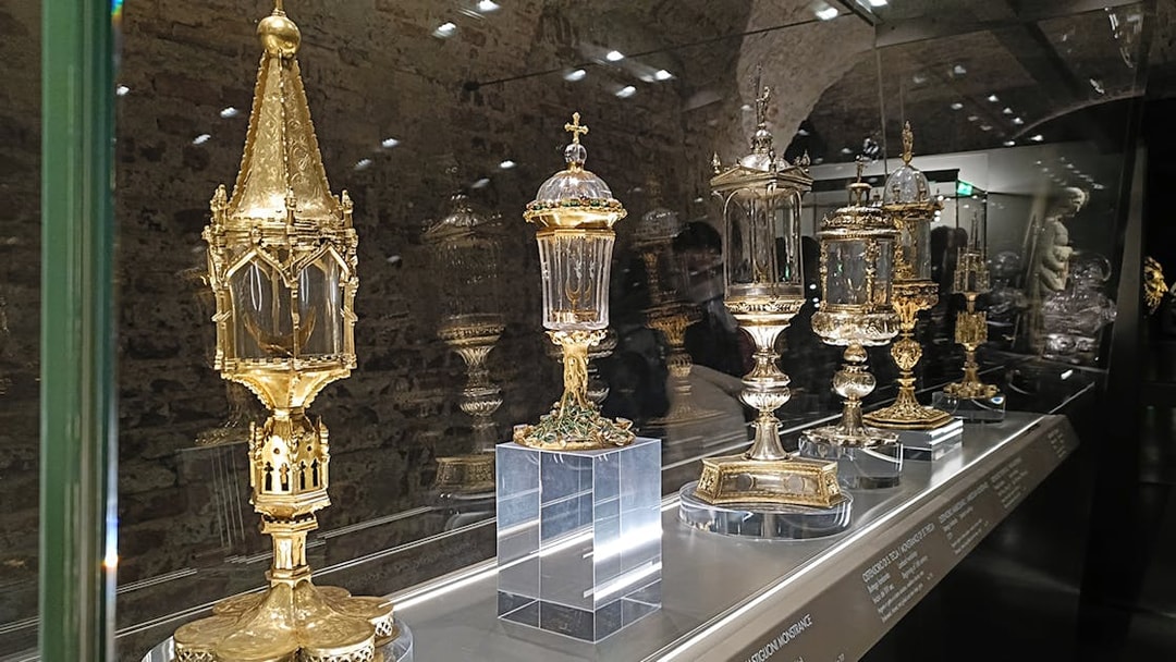 Golden religious artifacts displayed at Duomo Milan Museum exhibit.
