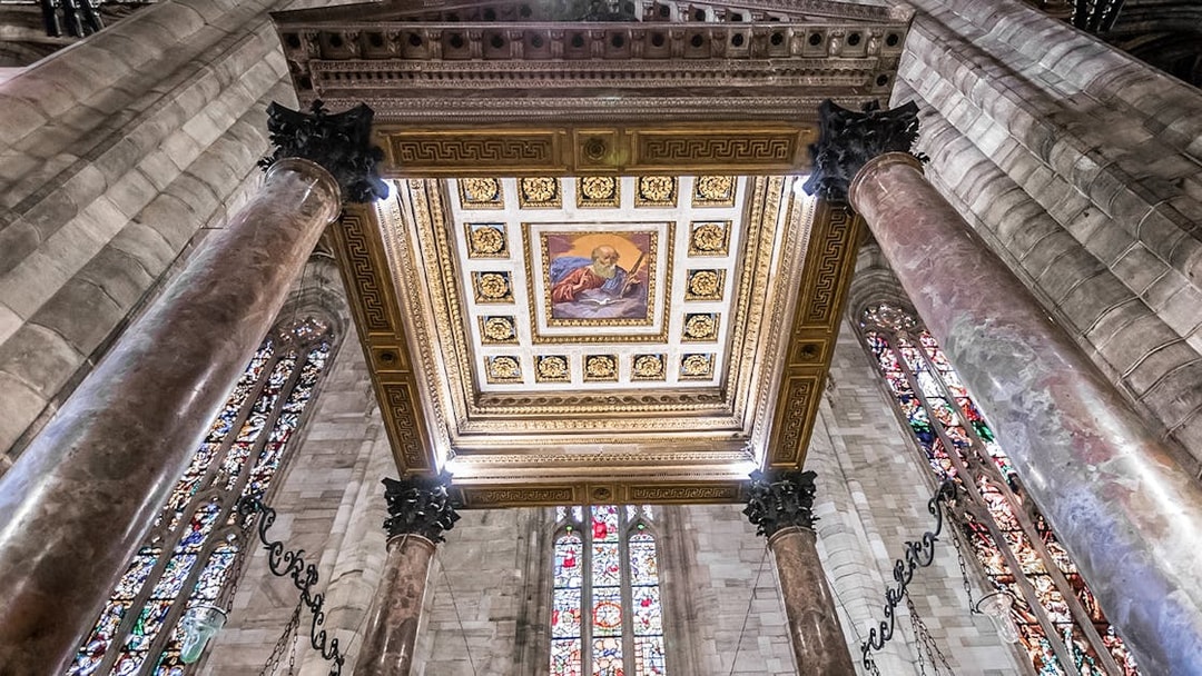 Ceiling and stained glass windows inside Duomo Cathedral, Milan.
