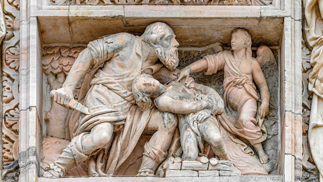 Relief sculpture on Milan Duomo depicting biblical scene with angel and figures.