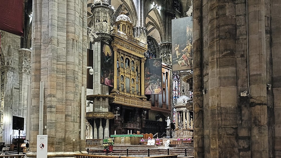Interior view of Milan Cathedral's ornate altar and columns.