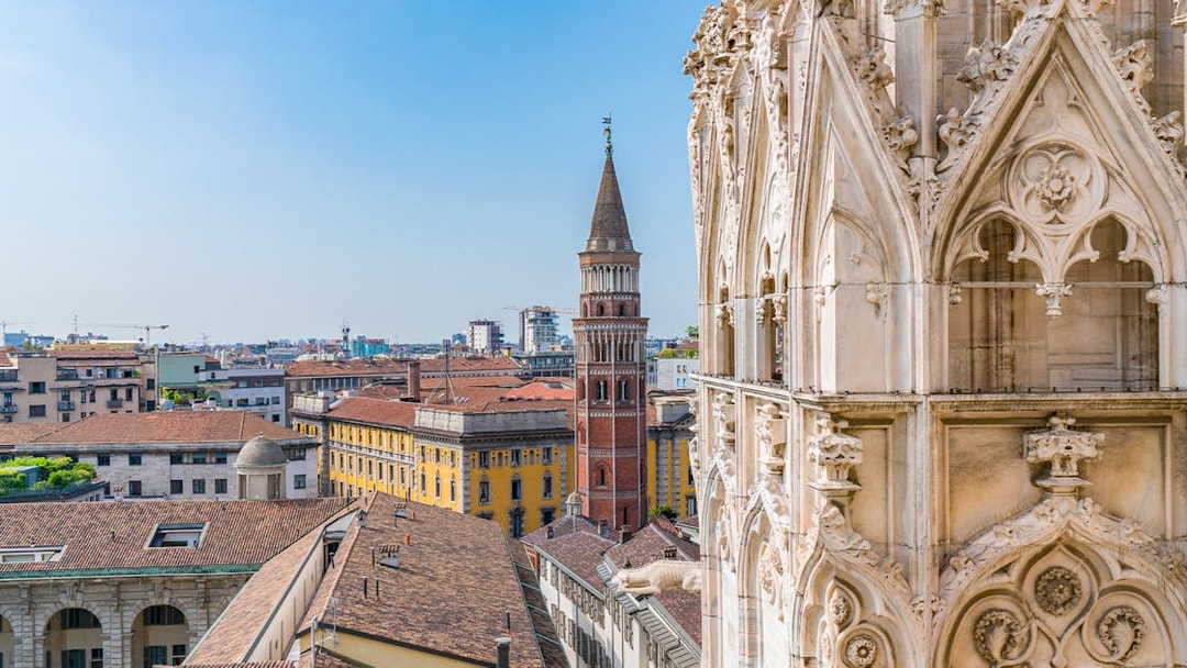 Milan Cathedral rooftop view with cityscape and historic tower.