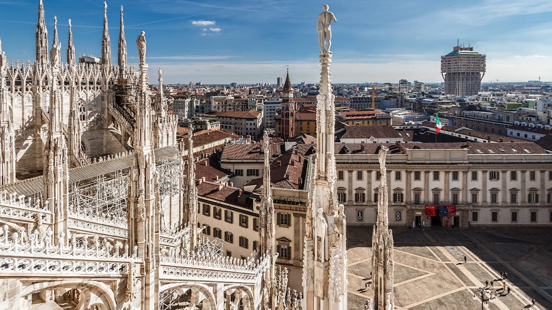 Duomo Milan rooftop view with spires and cityscape in the background.