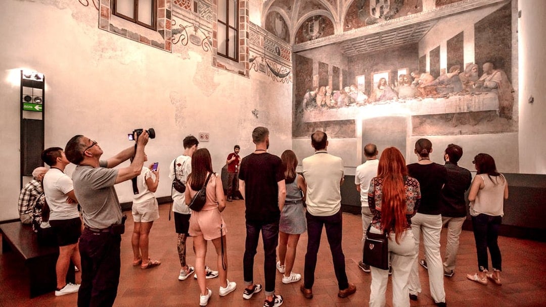 Tourists viewing The Last Supper mural inside Santa Maria delle Grazie, Milan.