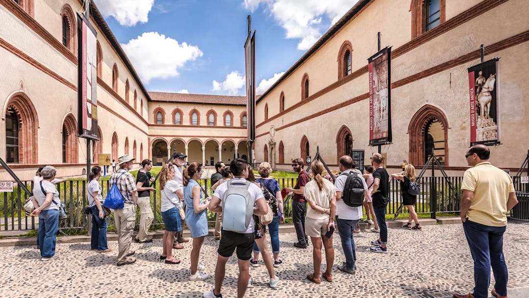 Tour group at Santa Maria delle Grazie, Milan, viewing historical architecture.