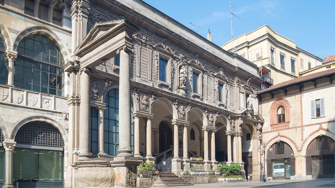 Historic architecture at Mercanti Square in Milan, featuring ornate columns and arches.