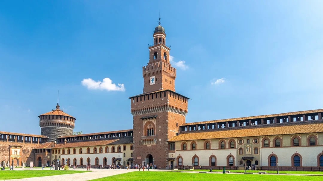 Sforza Castle courtyard in Milan with tourists exploring historic architecture.