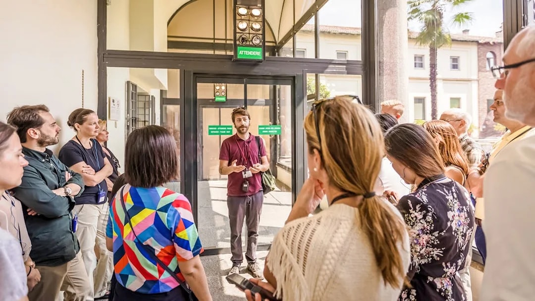 Guide speaking to tourists at The Last Supper Museum entrance.