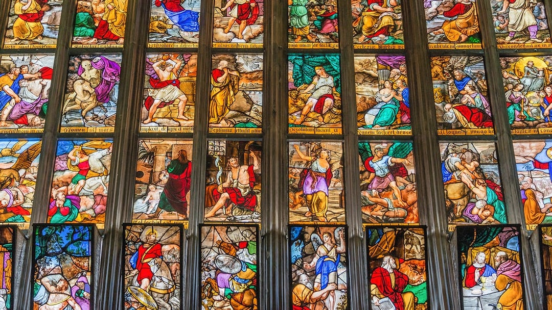 Stained glass windows depicting biblical scenes in Milan Duomo, Italy.