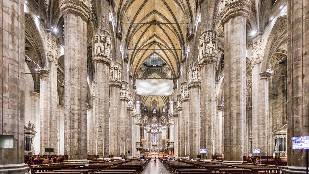 Duomo Milan Cathedral interior with tourists on guided tour, Italy.