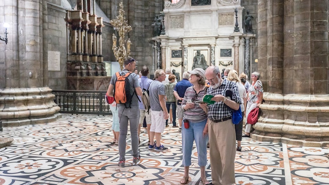 Tourists inside Milan Duomo Cathedral near Church of San Gottardo access.