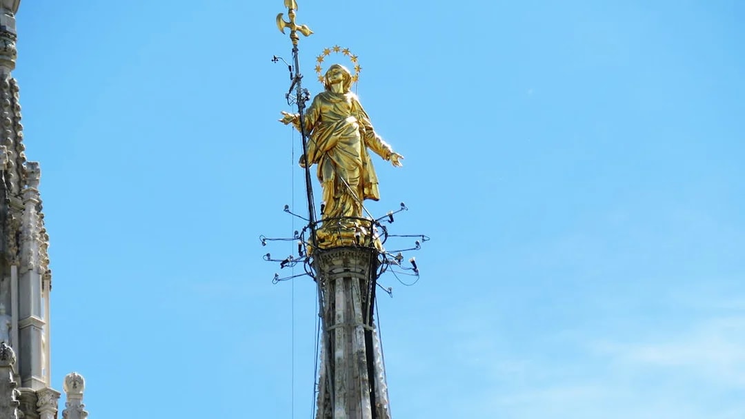 Madonnina statue on Duomo Cathedral rooftop, Milan, with repair scaffolding.
