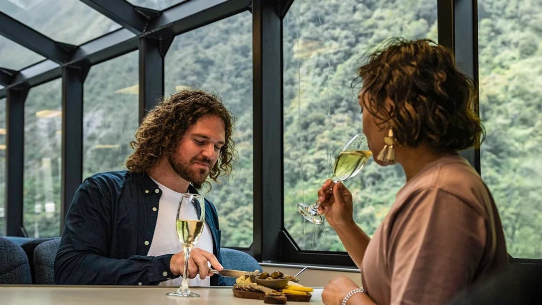 Couple enjoying gourmet canapés and champagne on Milford Sound cruise.
