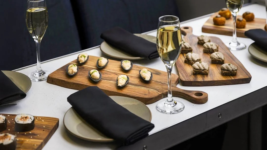 Gourmet canapés and champagne on a table during a Milford Sound cruise.