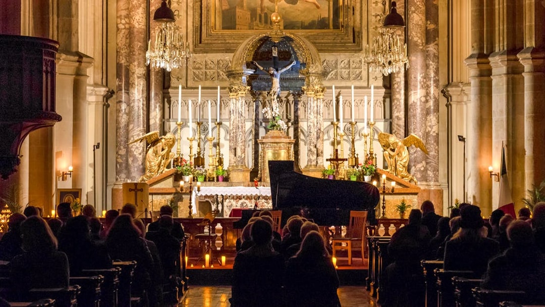 Classical concert audience at Minoritenkirche with grand piano and ornate altar.