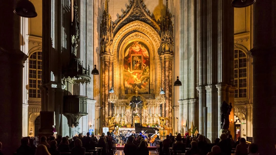 Classical concert at Minoritenkirche with audience seated in the illuminated church interior.