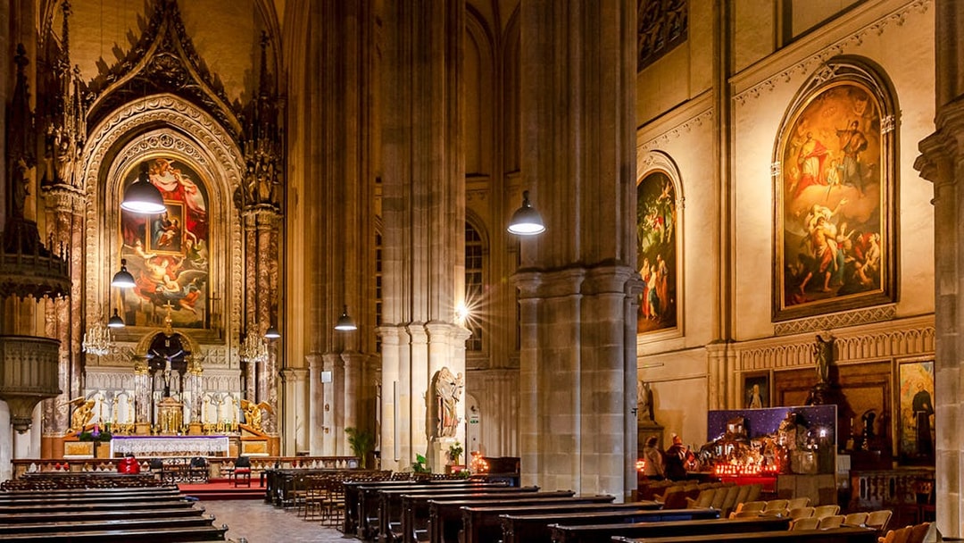 Interior of Minoritenkirche with ornate altar and classical paintings, Vienna concert venue.