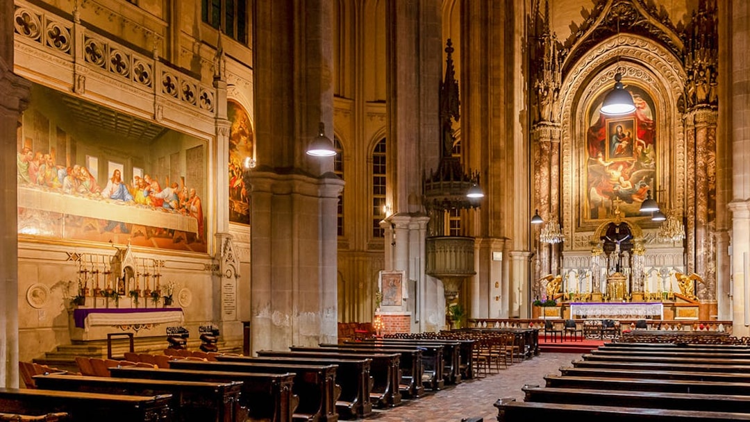 Classical concert setting inside Minoritenkirche, Vienna, with ornate altar and Last Supper mural.