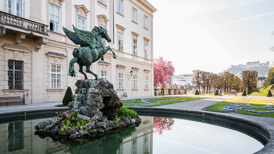 Pegasus statue in Mirabell Palace gardens, Salzburg, with Hohensalzburg Fortress in the background.