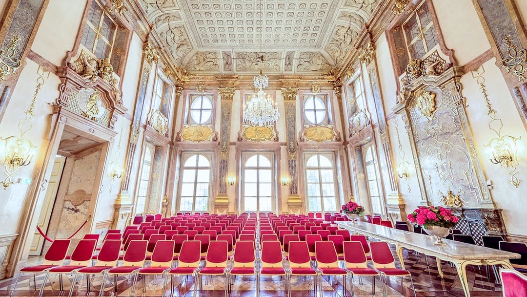 Empty red seats in ornate hall at Mirabell Palace, Salzburg.
