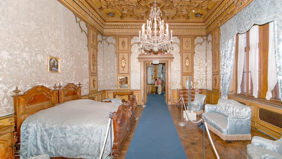 Miramare Castle bedroom with ornate bed and historical furnishings in Trieste, Italy.