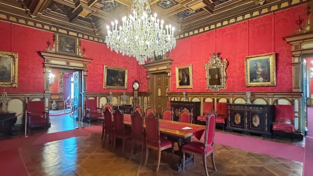 Miramare Castle Throne Room with chandelier and red furnishings in Trieste, Italy.