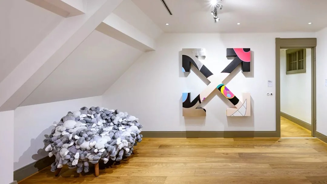 KAWS artwork and plush chair at Moco Museum, Amsterdam art tour.