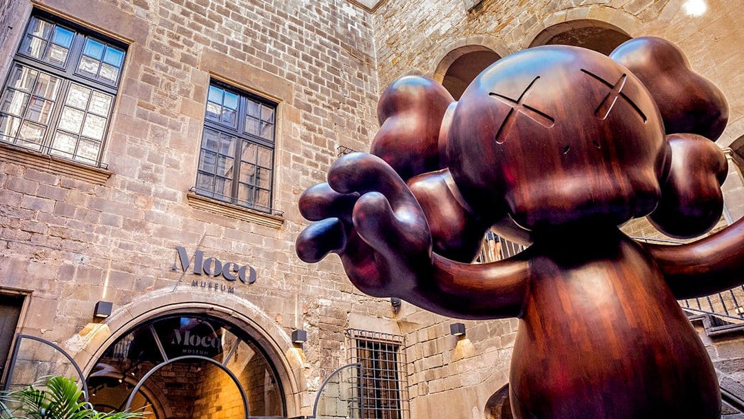 Moco Museum entrance in Barcelona with large sculpture, featuring Banksy artworks.