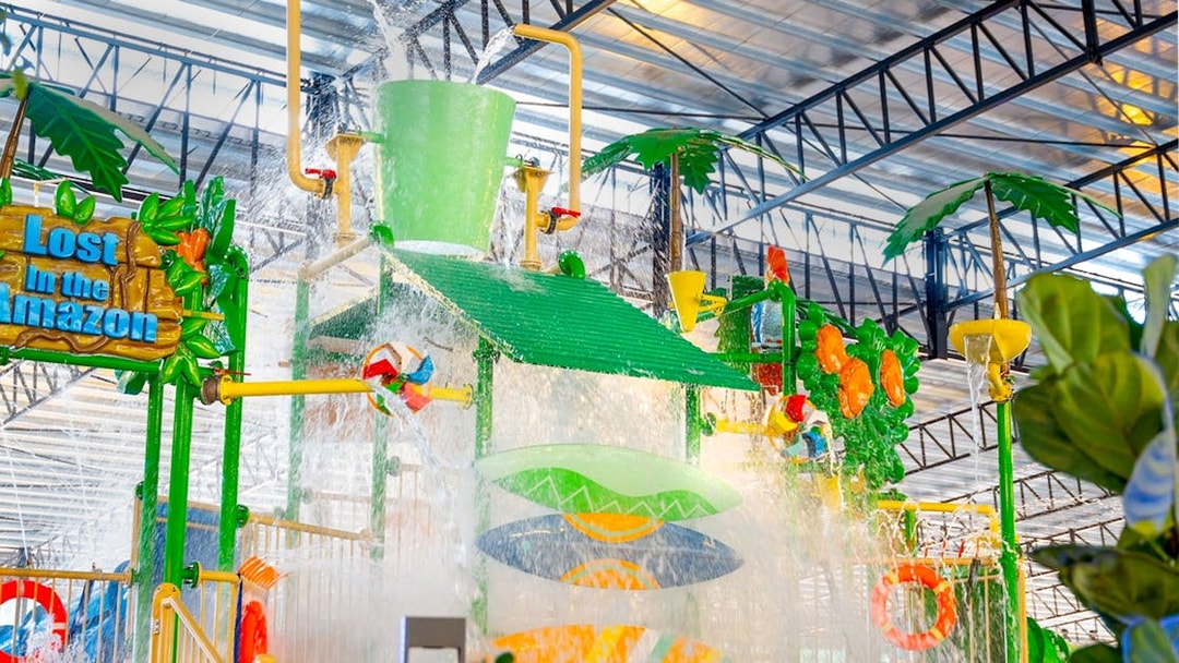 Water play area with large bucket splash at Monkeys Splash Zone, Lost in the Amazon theme.