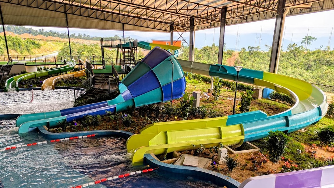 Water slides in the Splash Zone play area with lush greenery in the background.