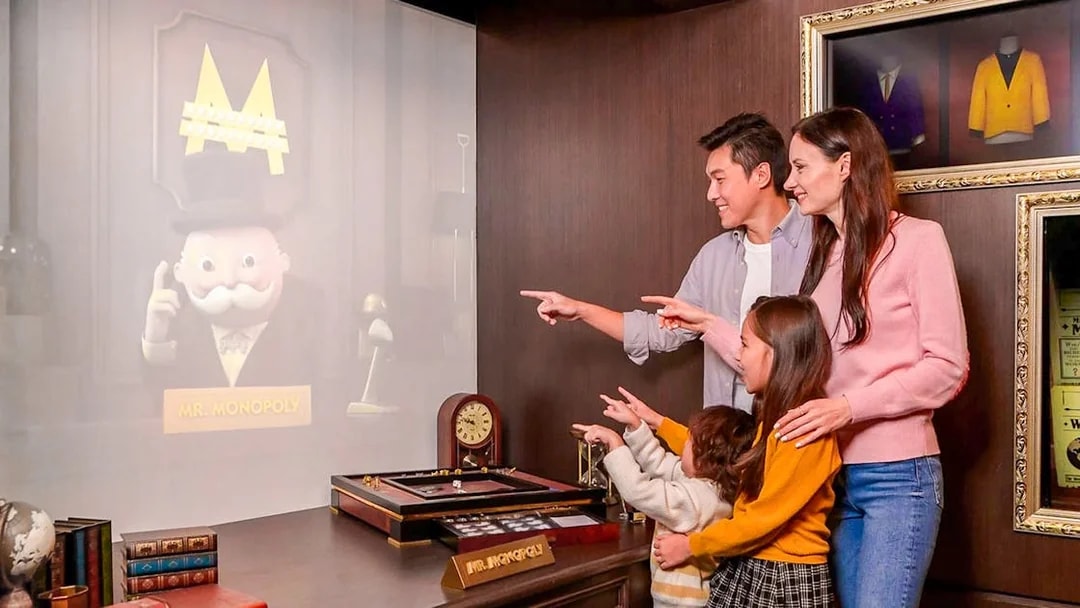 Family interacting with Mr. Monopoly hologram at Monopoly Dreams Melbourne.
