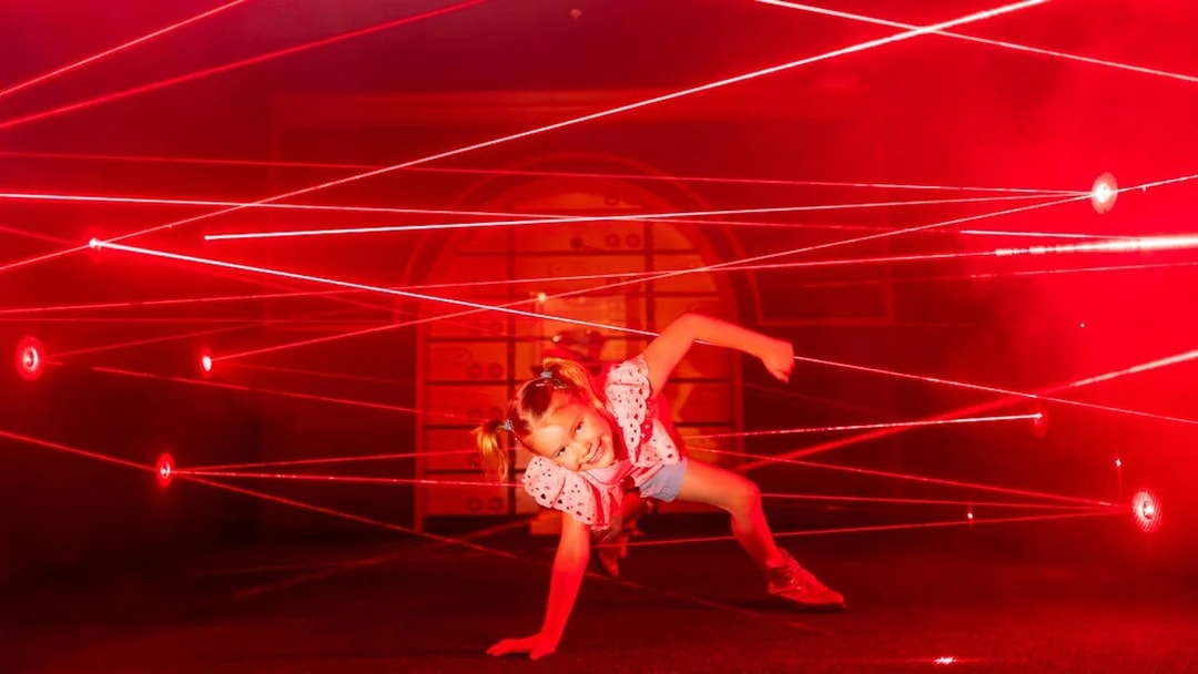 Child navigating laser maze at Monopoly Dreams Melbourne.