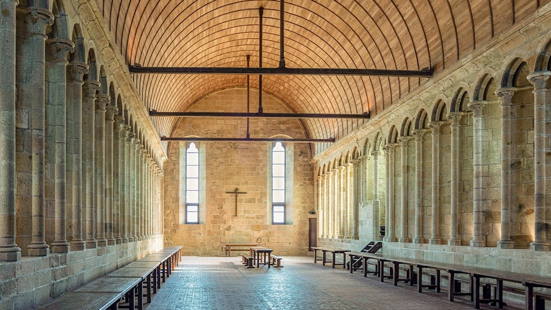 Interior arches and stone columns of Mont Saint Michel Abbey in France.