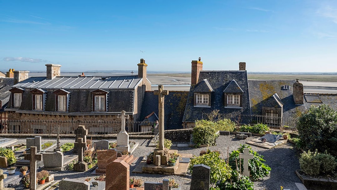 Rooftop view of Mont-Saint-Michel Abbey with surrounding landscape.