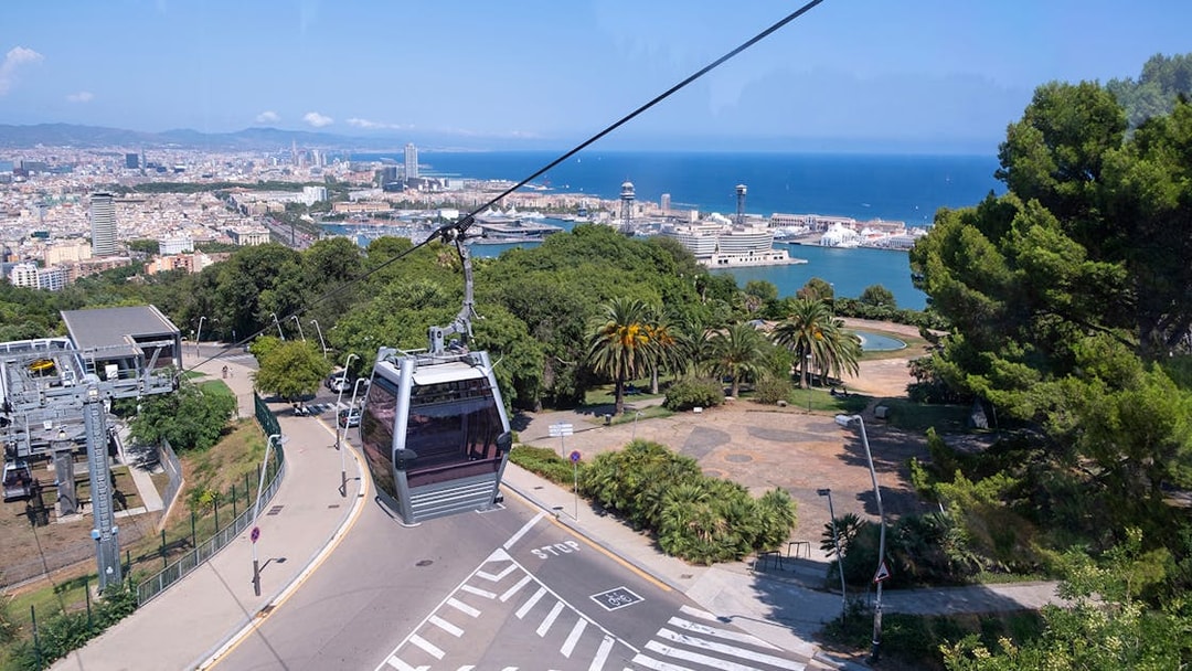 Cable car ascending Montjuic Hill with view of Sagrada Familia in background, Barcelona.