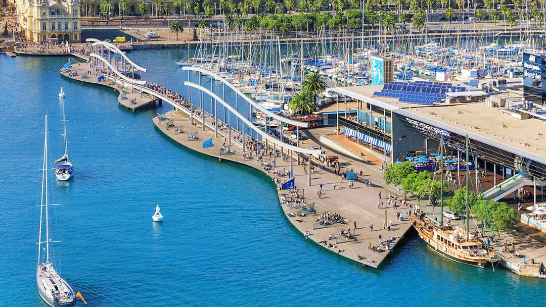 Aerial view of Barcelona's Port Vell with boats and promenade near Montjuic cable car station.