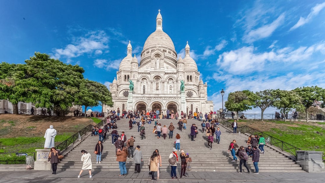 Basilica of the Sacred Heart with visitors on steps during Montmartre Train tour.