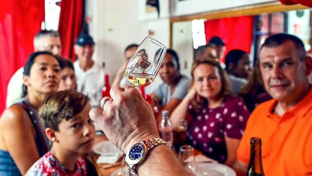 Tasting session at a Paris Saint Germain food tour with a group observing a wine glass.