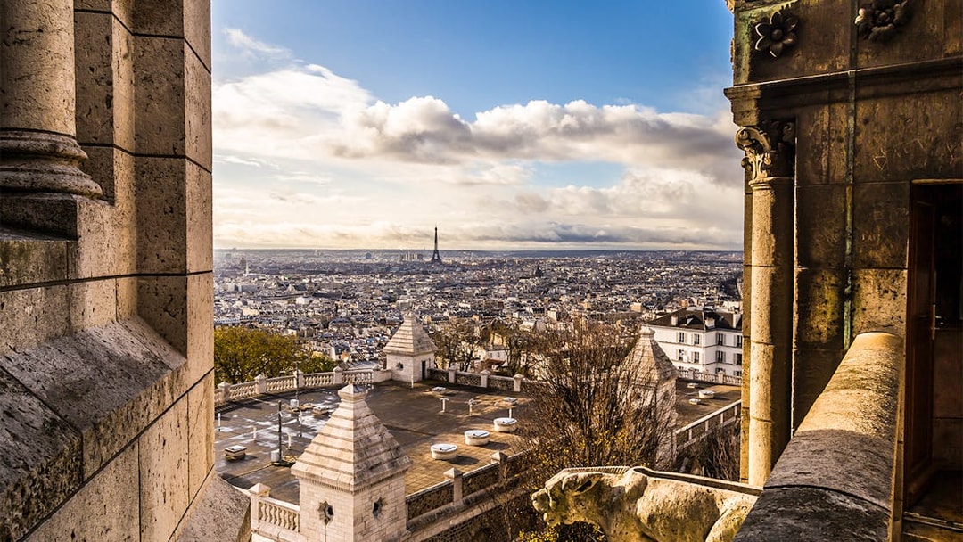 View of Paris skyline from Sacré Coeur Basilica, featuring Eiffel Tower in the distance.