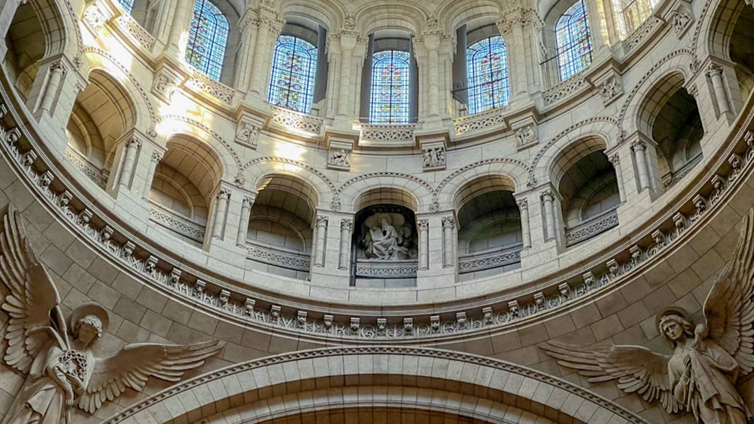Interior view of Sacre Coeur dome with stained glass and angel sculptures, Montmartre, Paris.
