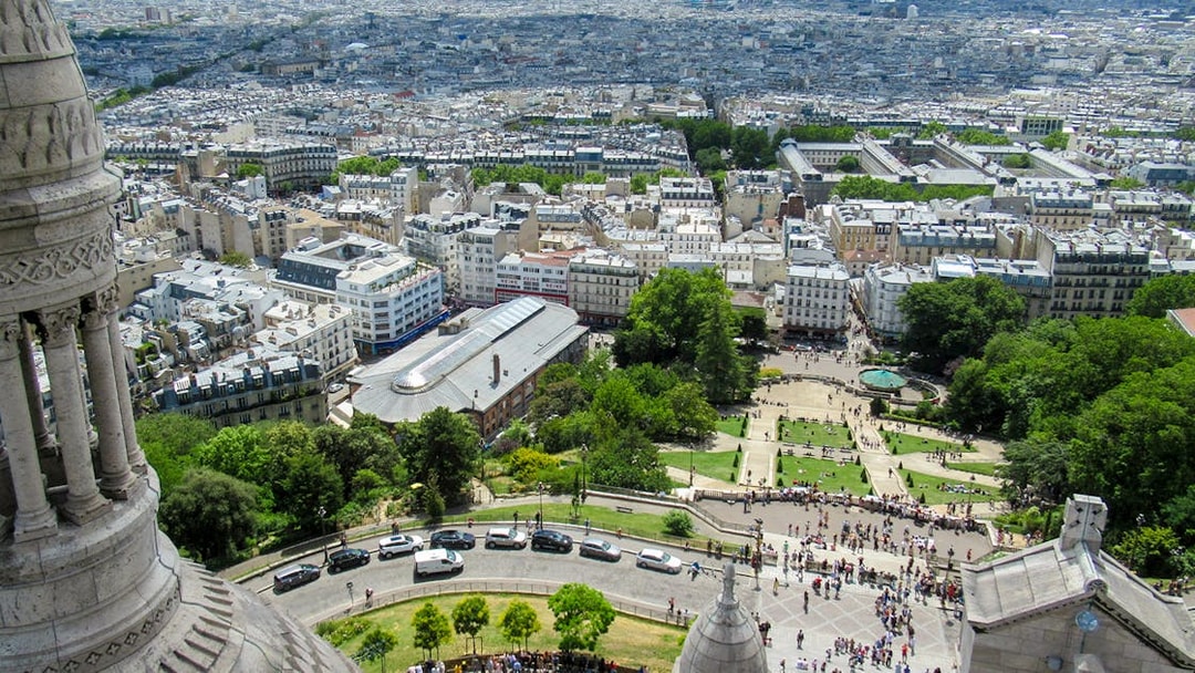 View of Paris from Montmartre Sacré-Cœur Cathedral, overlooking cityscape and gardens.
