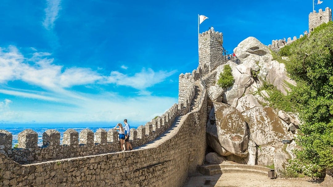 Moorish Castle tower with visitors enjoying panoramic view of Sintra, Portugal.