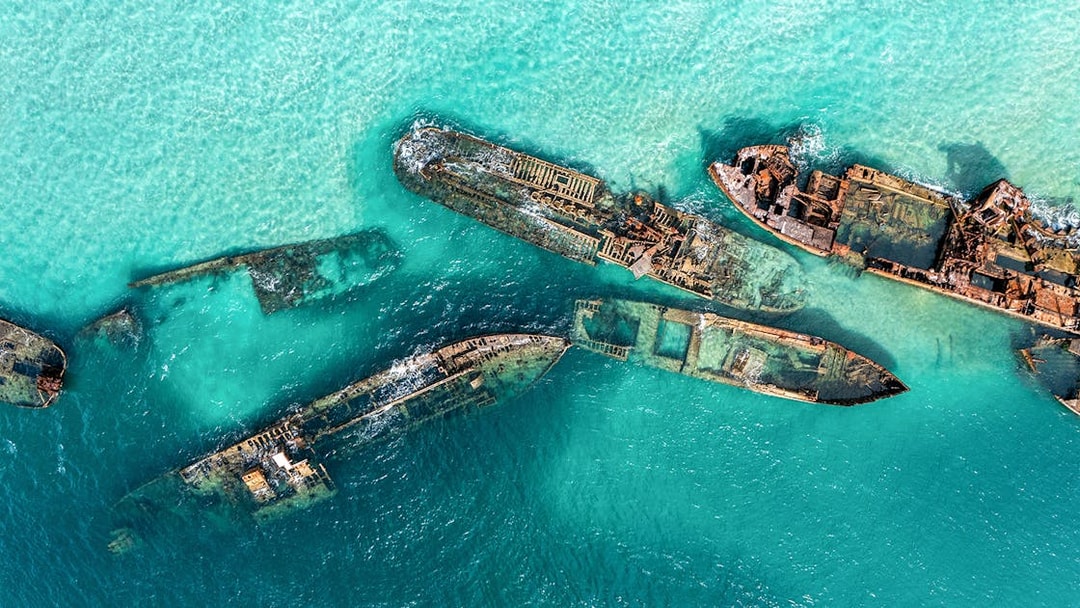 Aerial view of shipwrecks in turquoise waters at Moreton Island, Australia.