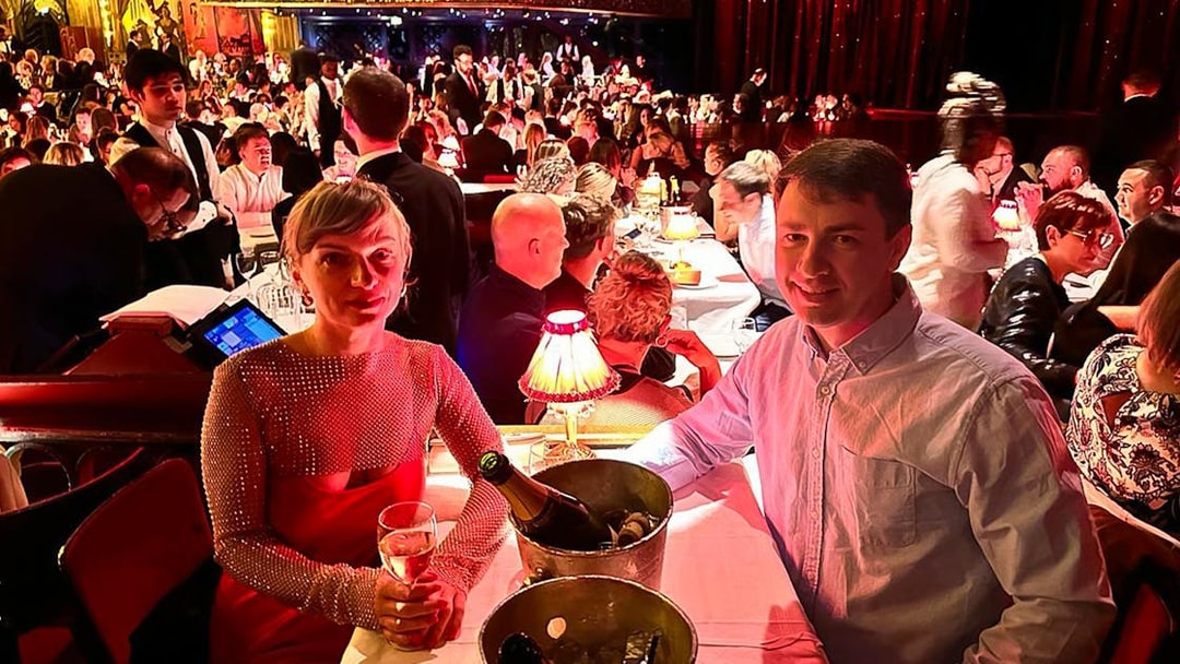 Couple enjoying champagne at a table during the Moulin Rouge show in Paris.