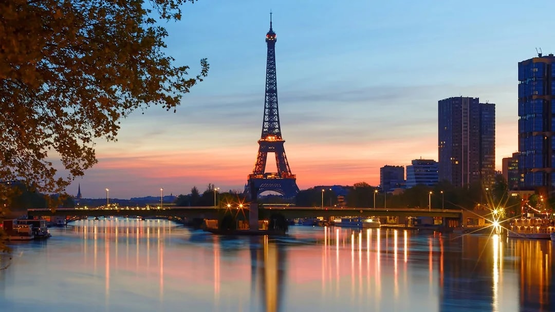 Eiffel Tower at sunset with Seine River reflections, Paris.