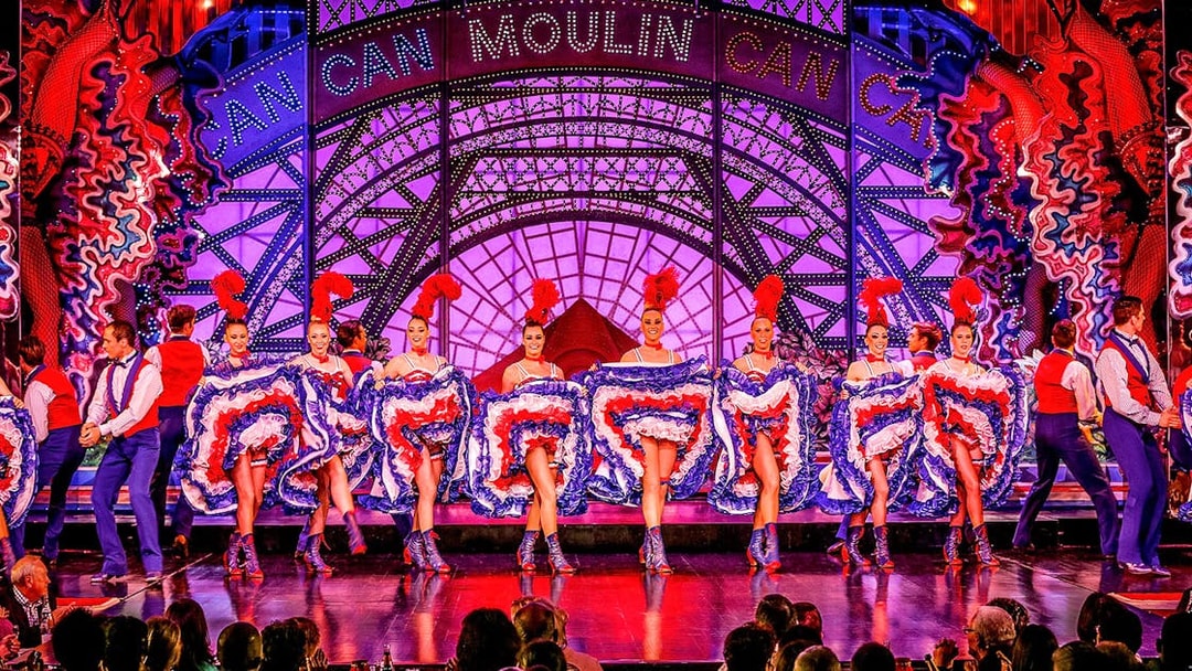Cabaret dancers performing at Moulin Rouge in Paris with vibrant costumes.